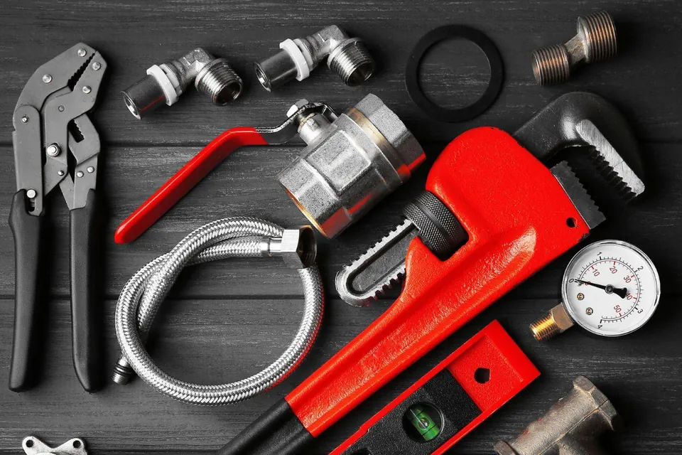 Plumbing tools: pipe wrench, pliers, pressure gauge, shutoff valve, braided supply hose and fittings